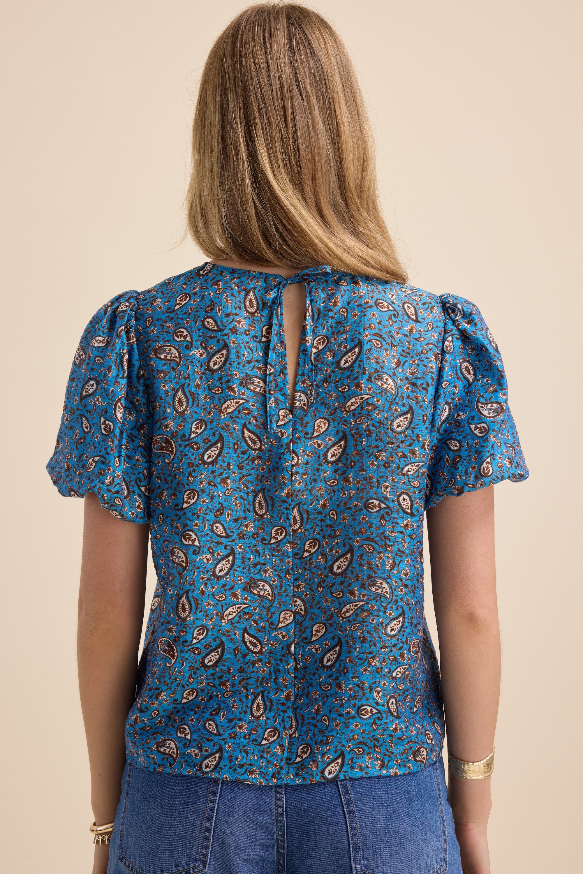 Woman in Max’s Sydney Back Detail Top and denim skirt, seen from the back.