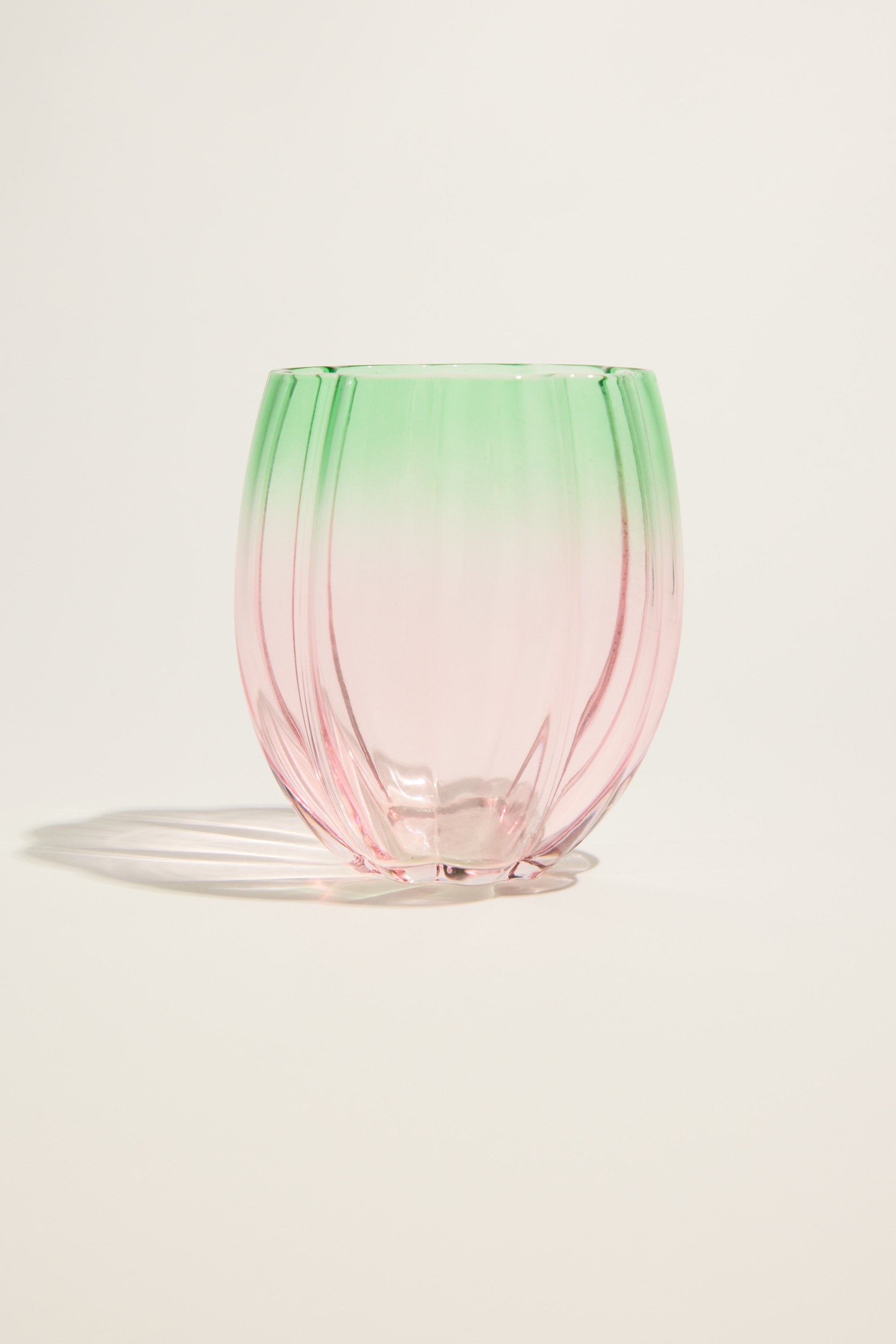 The Homelab Petal Stemless Glass Set features round, ribbed tumblers with a gradient design—light green at the top fading to pink at the bottom—creating standout glassware from Homelab.