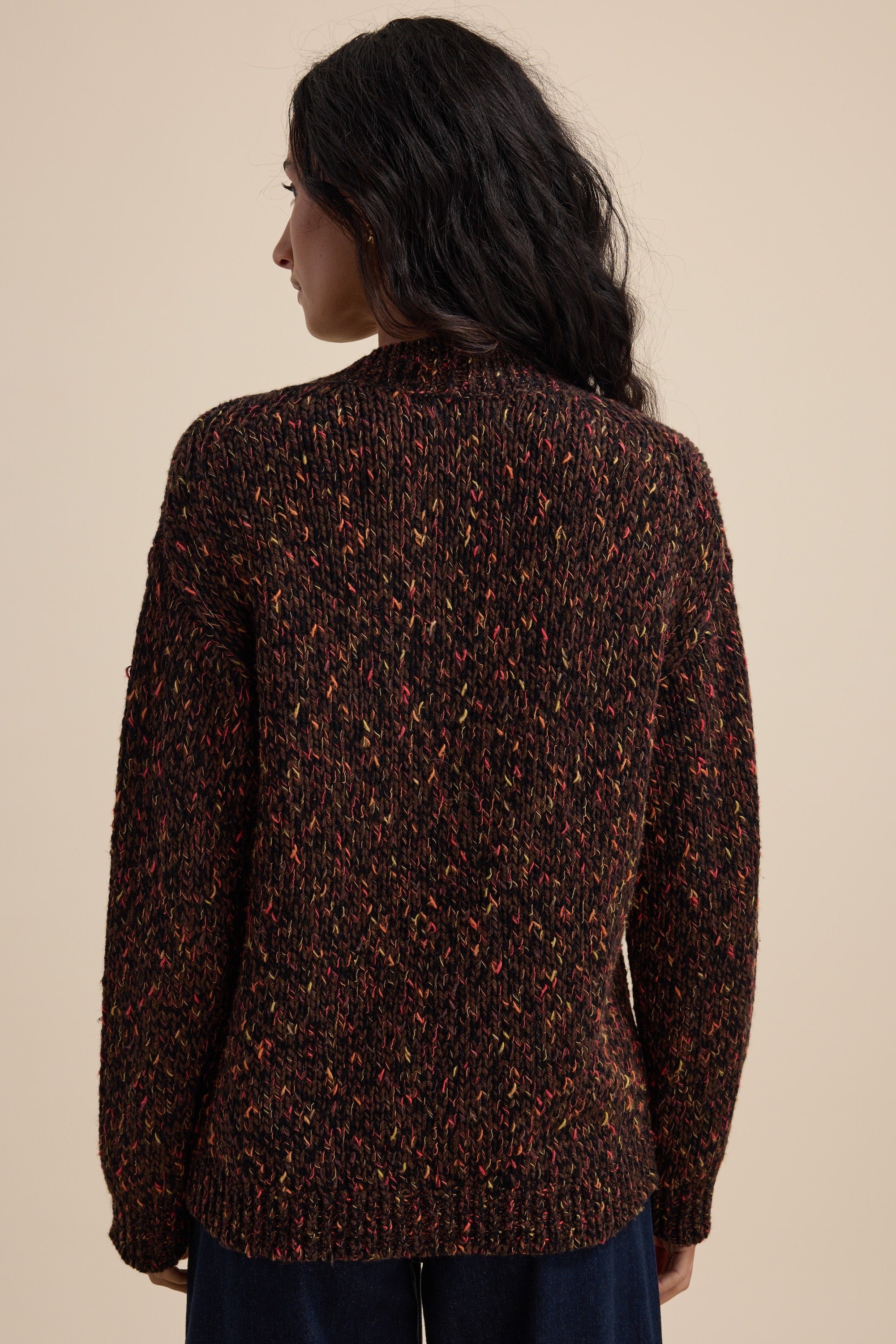 Woman with long dark hair wears Elementary Oversized Merino Blend Cardigan, seen from the back.