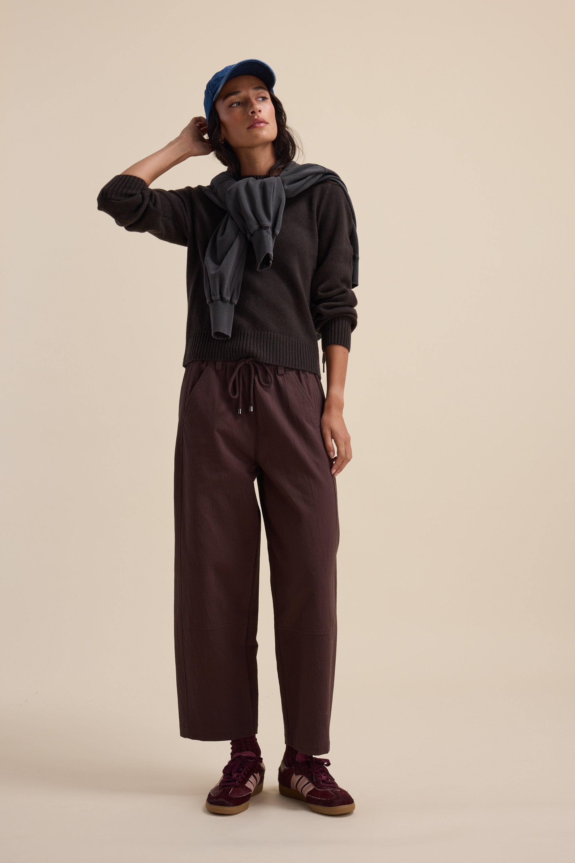 Person in casual outfit: Elementary Cashmere Blend Crew Neck Sweater, gray sweatshirt, brown pants.