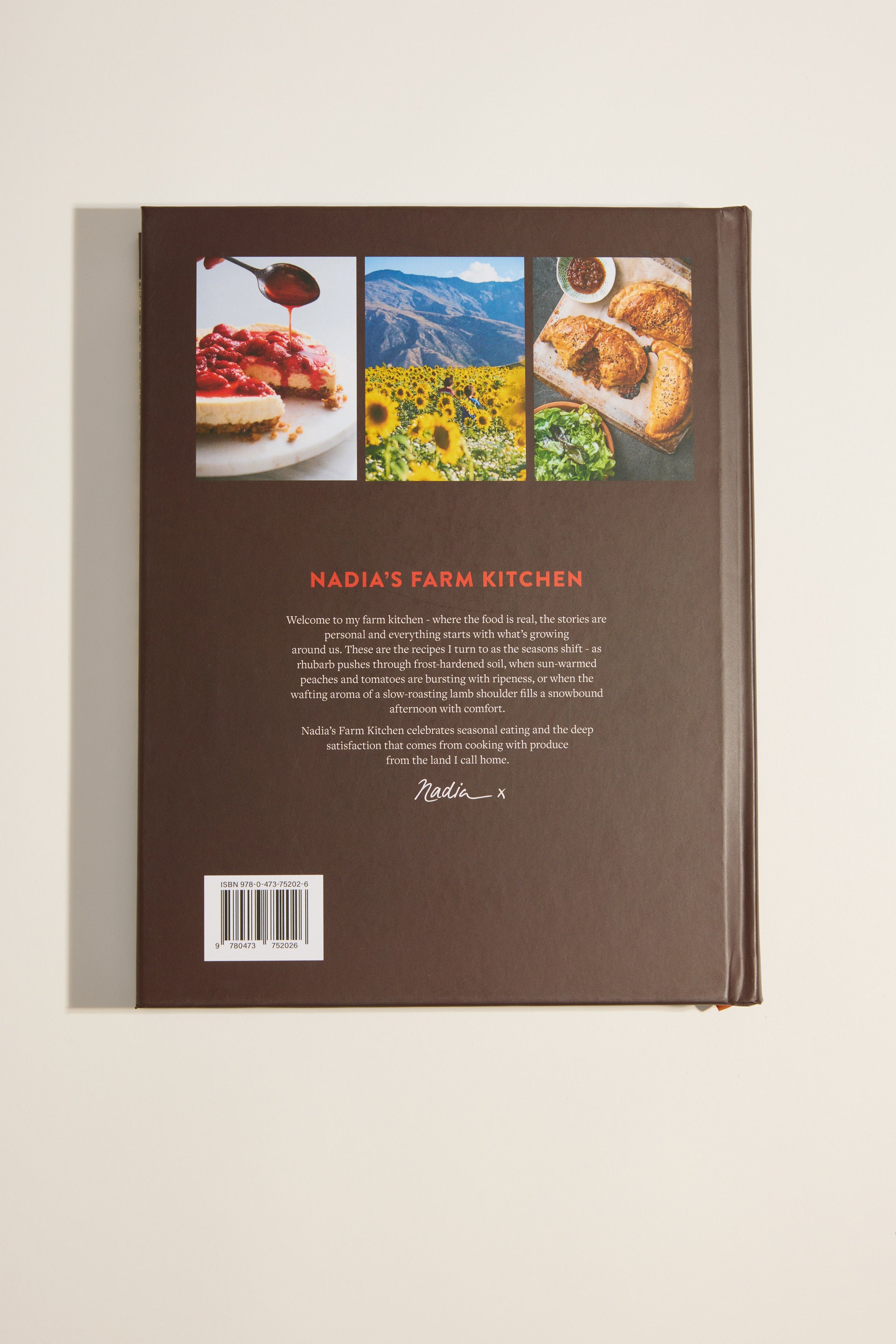 The back cover of Nadia's Farm Kitchen Book by Other shows three photos—a dessert, a sunflower field on a New Zealand farm, and pastries—plus a book description about seasonal recipes, a barcode, and Nadia Lim’s signature.