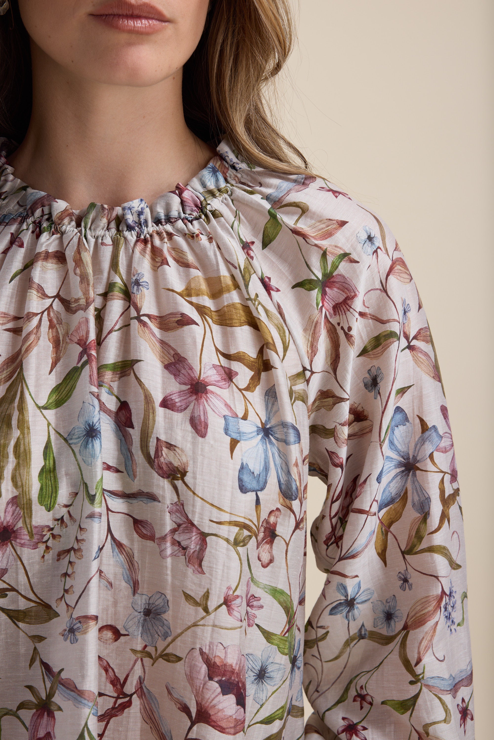 Woman in Max Quinn Gather Detail Blouse with pink, blue, and green botanical prints.