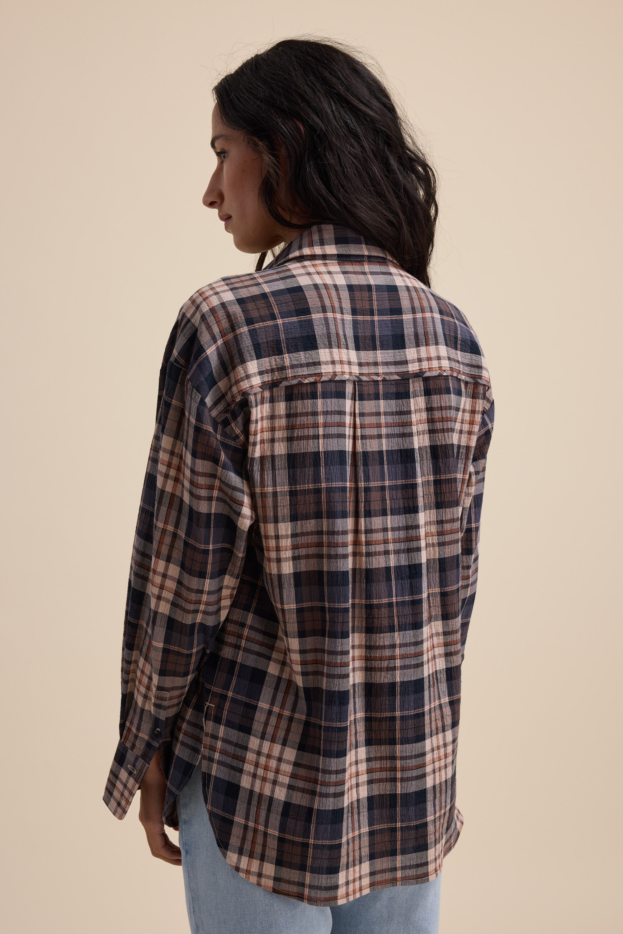 Person in an Elementary Textured Shirt and jeans, standing with their back to the camera.