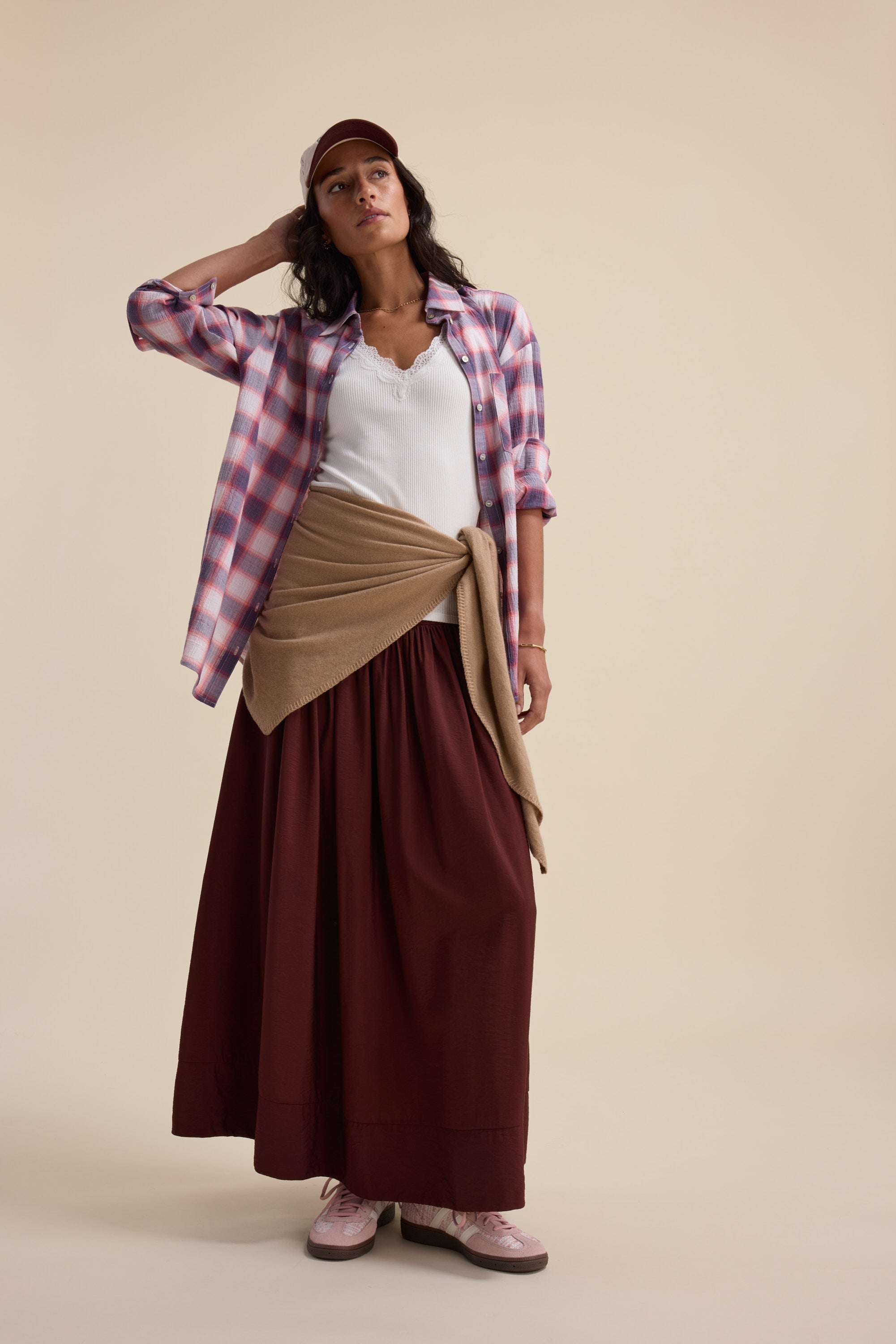 Woman in Elementary Textured Shirt, tank top, long skirt, sneakers, and baseball cap.