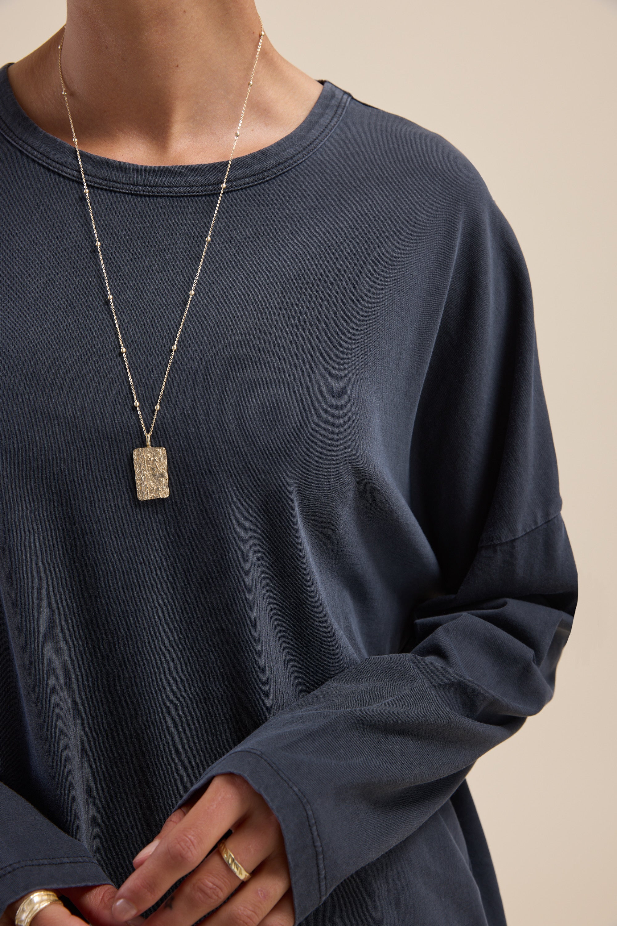 Person wearing the Max Elementary Slouchy Long Sleeve Tee and a rectangular pendant necklace.