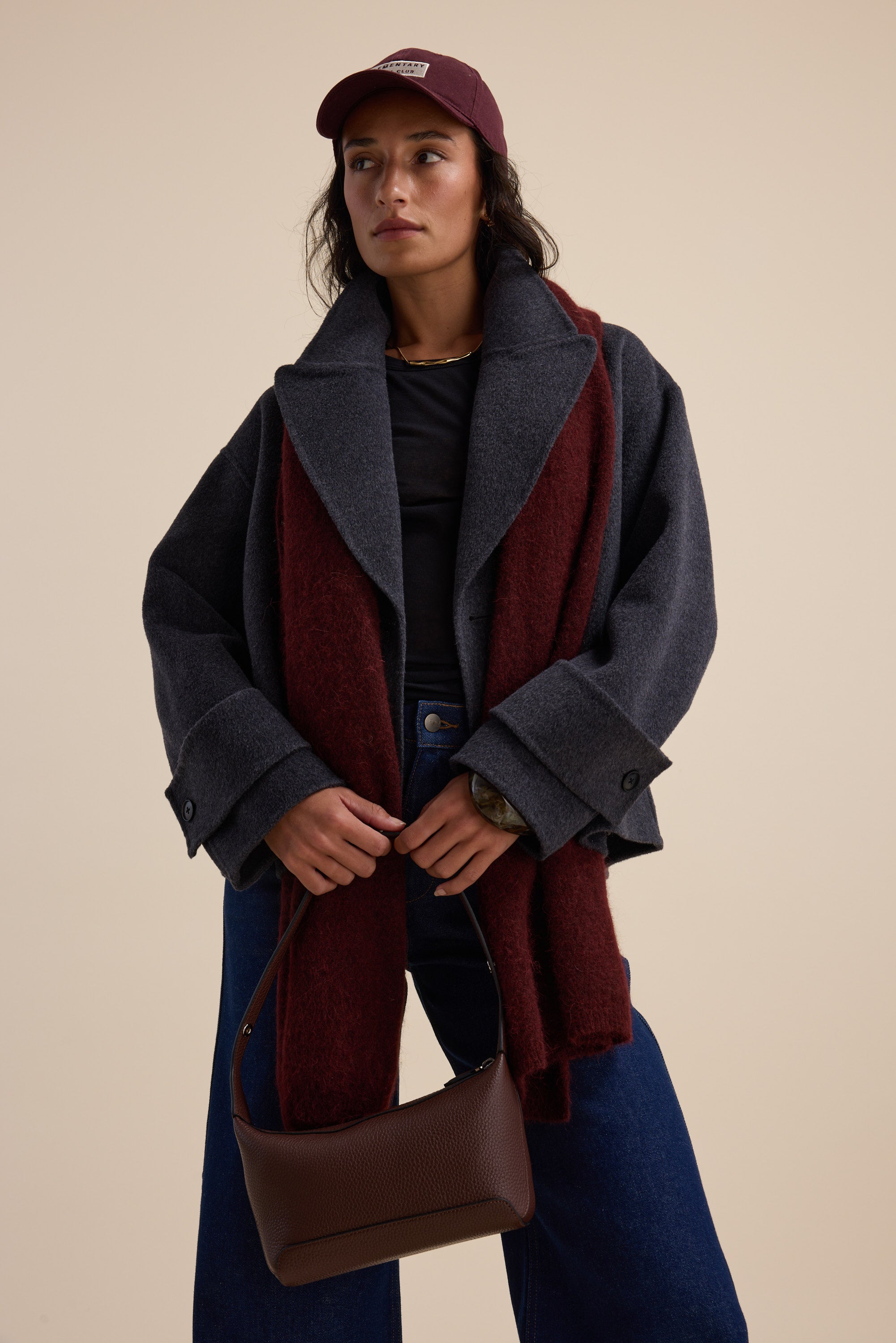 Woman in Max's Double Breasted Wool Blend Coat, red scarf, cap, and brown handbag.