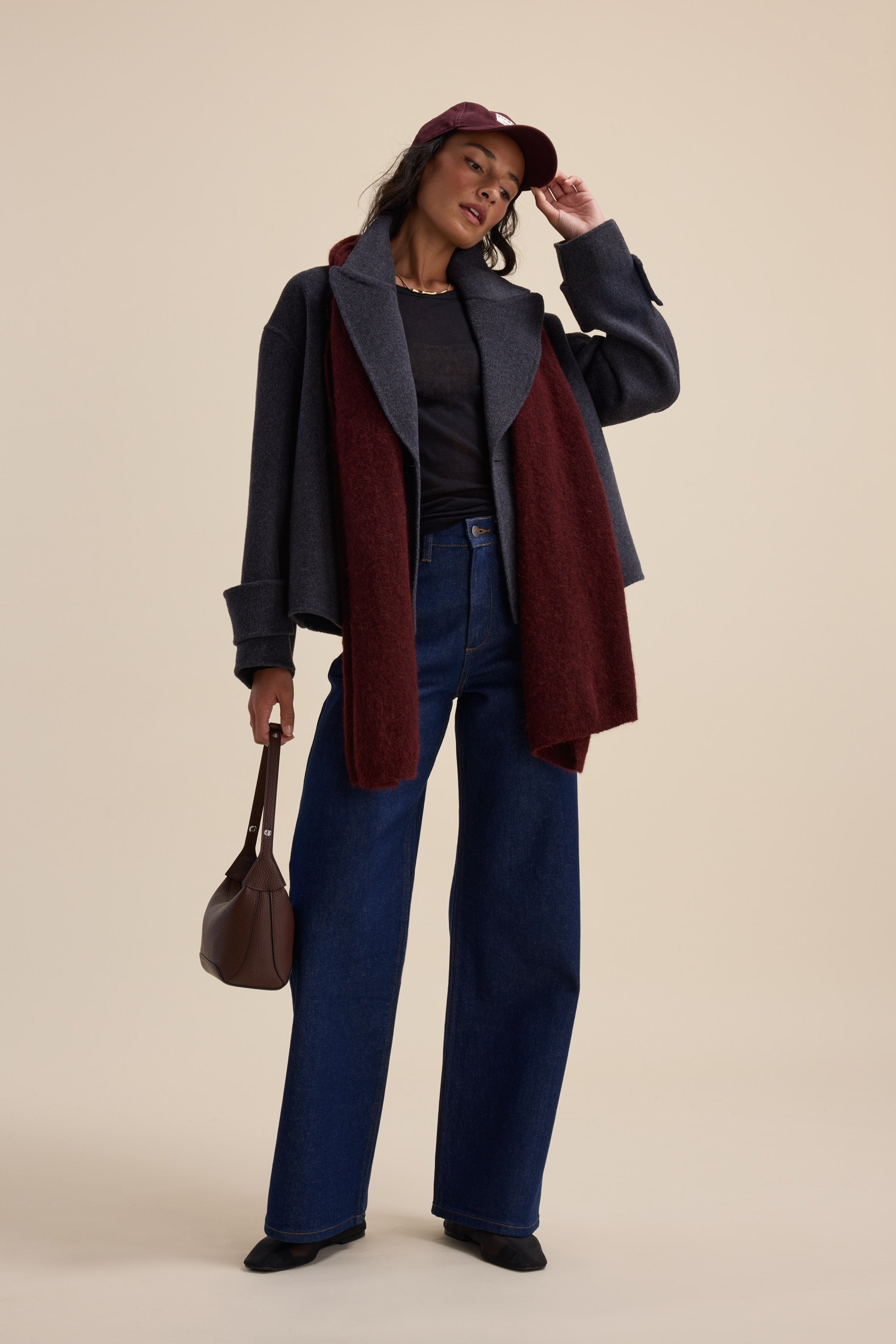 Woman in wide-leg jeans, Max Double Breasted Wool Blend Coat, burgundy scarf, brown purse.