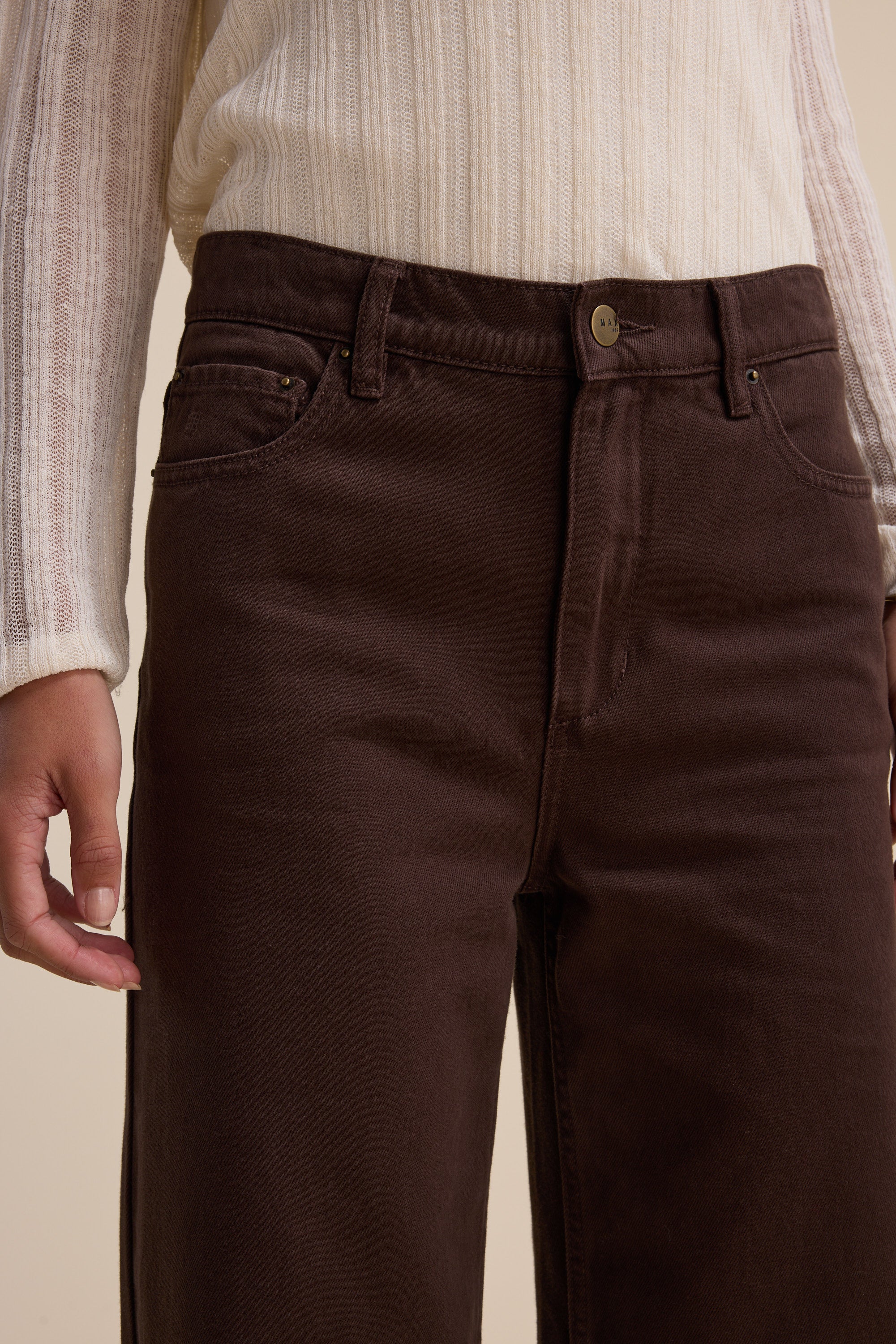 Person in a cream ribbed sweater and Max’s Alaska Wide Leg Jeans, hand relaxed at their side..