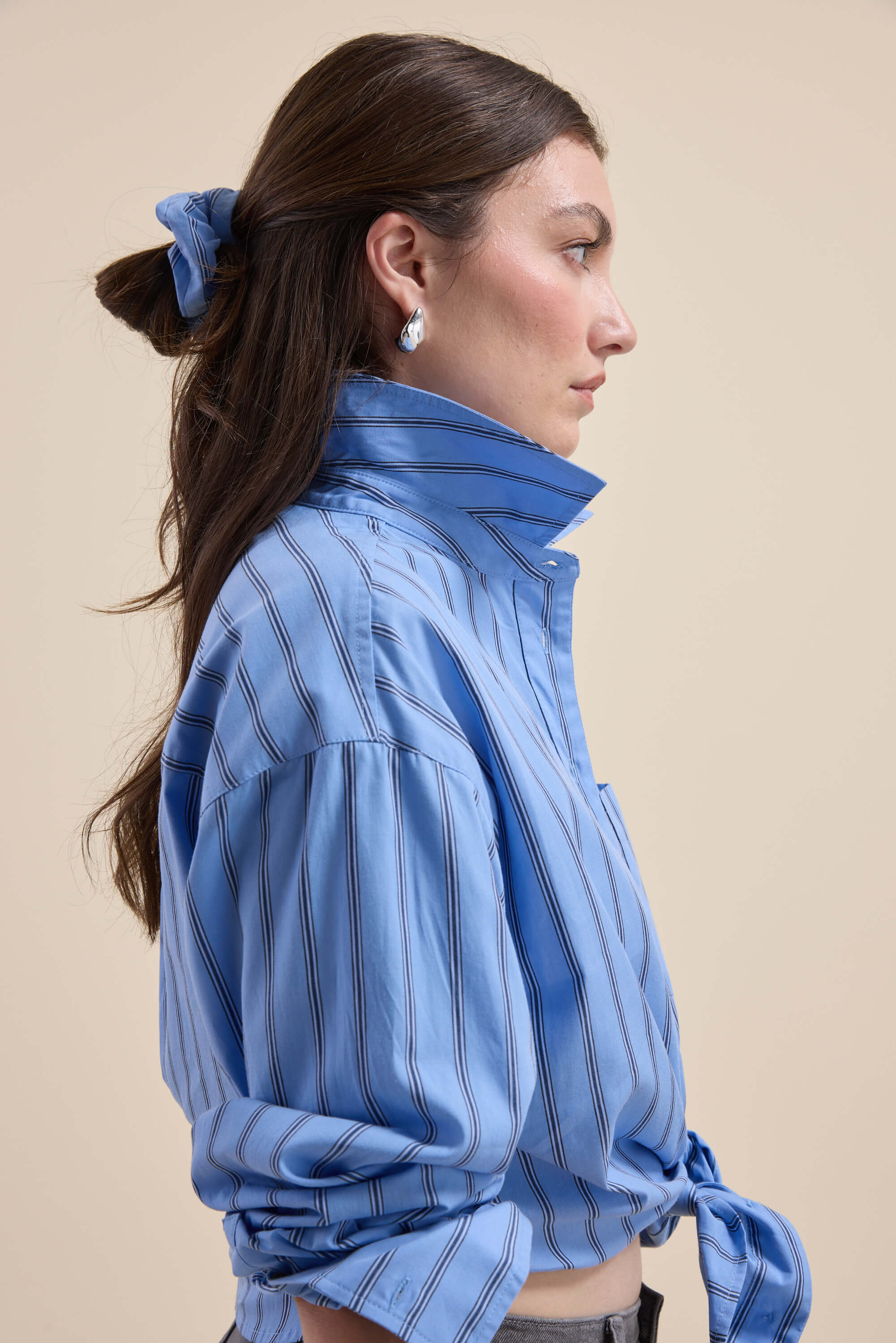 Woman in a Max Cameron Oversized Shirt and matching scrunchie, shown in profile view.