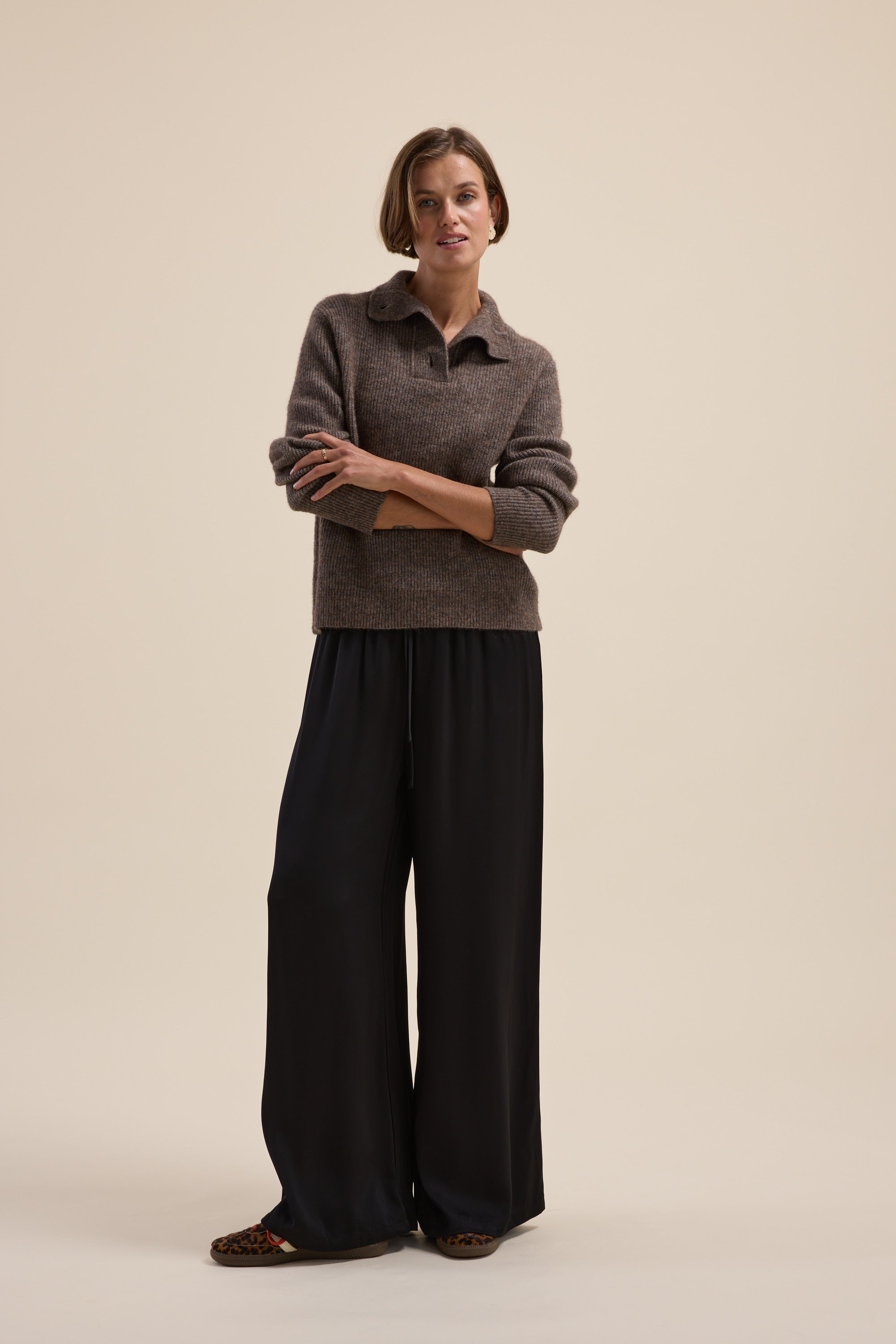 Woman in Elementary Collar Detail Sweater by Elementary, standing against a beige background.