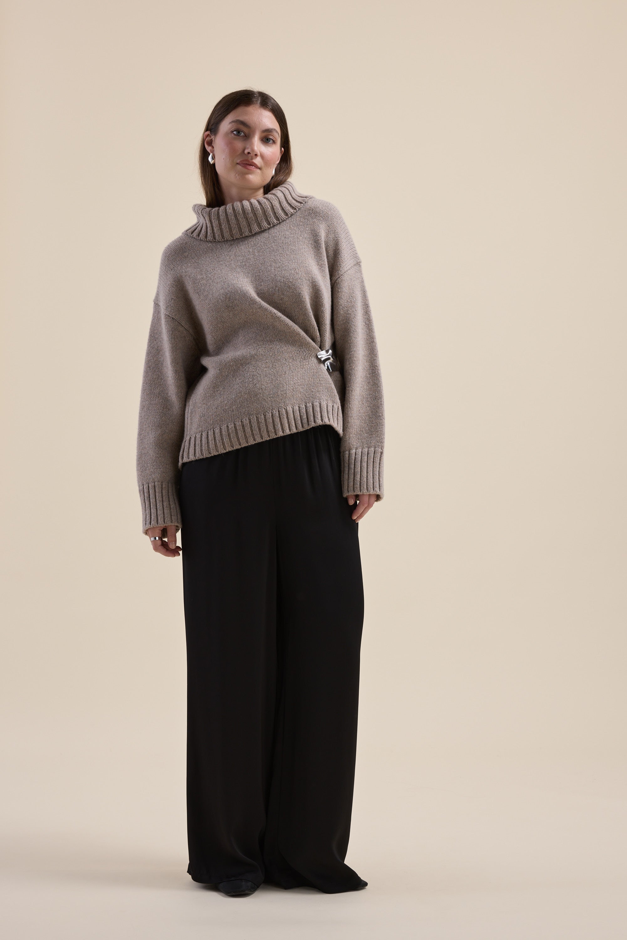 Woman wears Max Holly Wool Blend Roll Neck Sweater and black wide-leg pants on a neutral background.