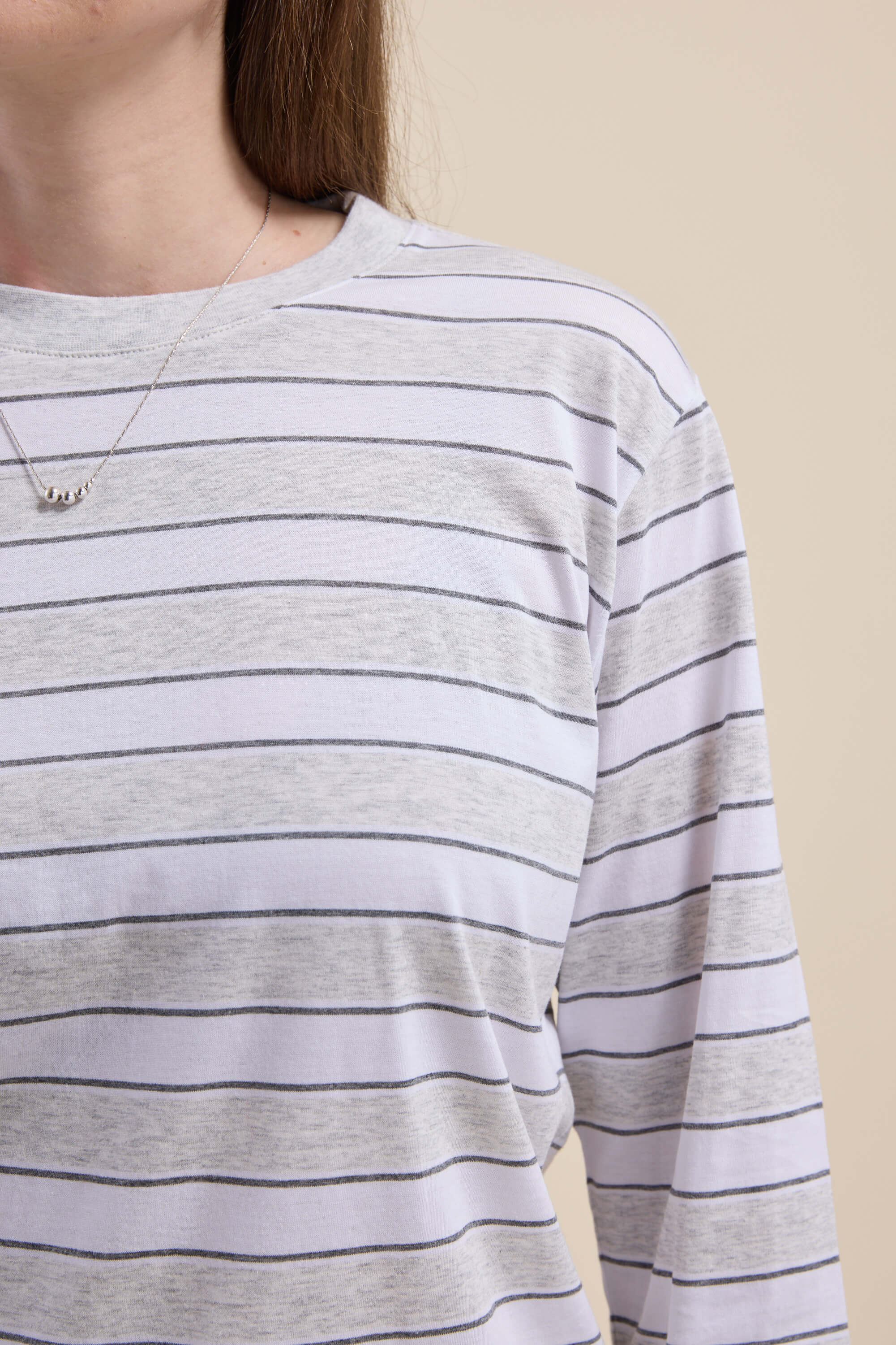 Model in Max Carmen Long Sleeve Stripe Tee, gray and white stripes, shoulders to chest.