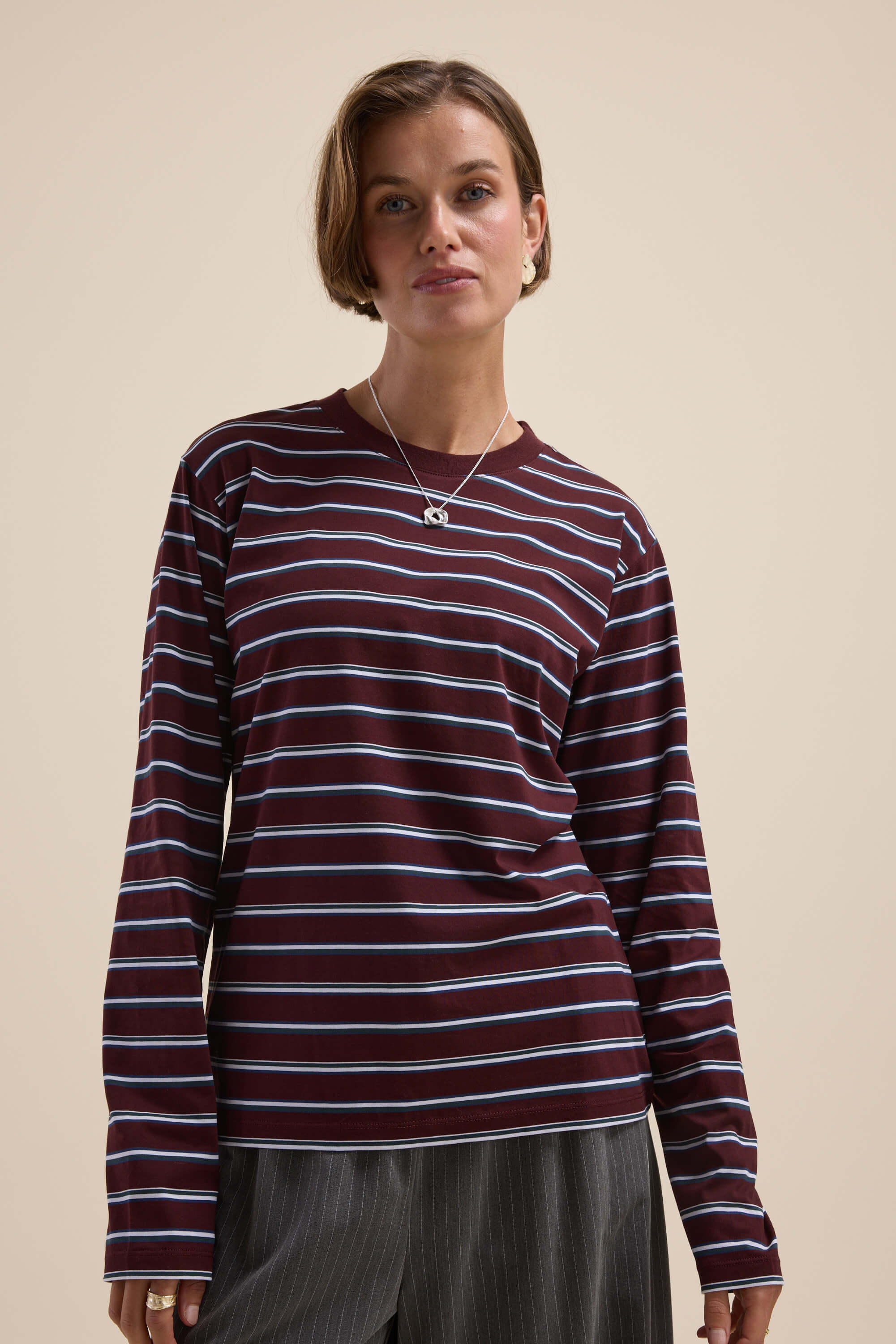 Woman wearing the Max Carmen Long Sleeve Stripe Tee with a relaxed fit and pinstriped pants.