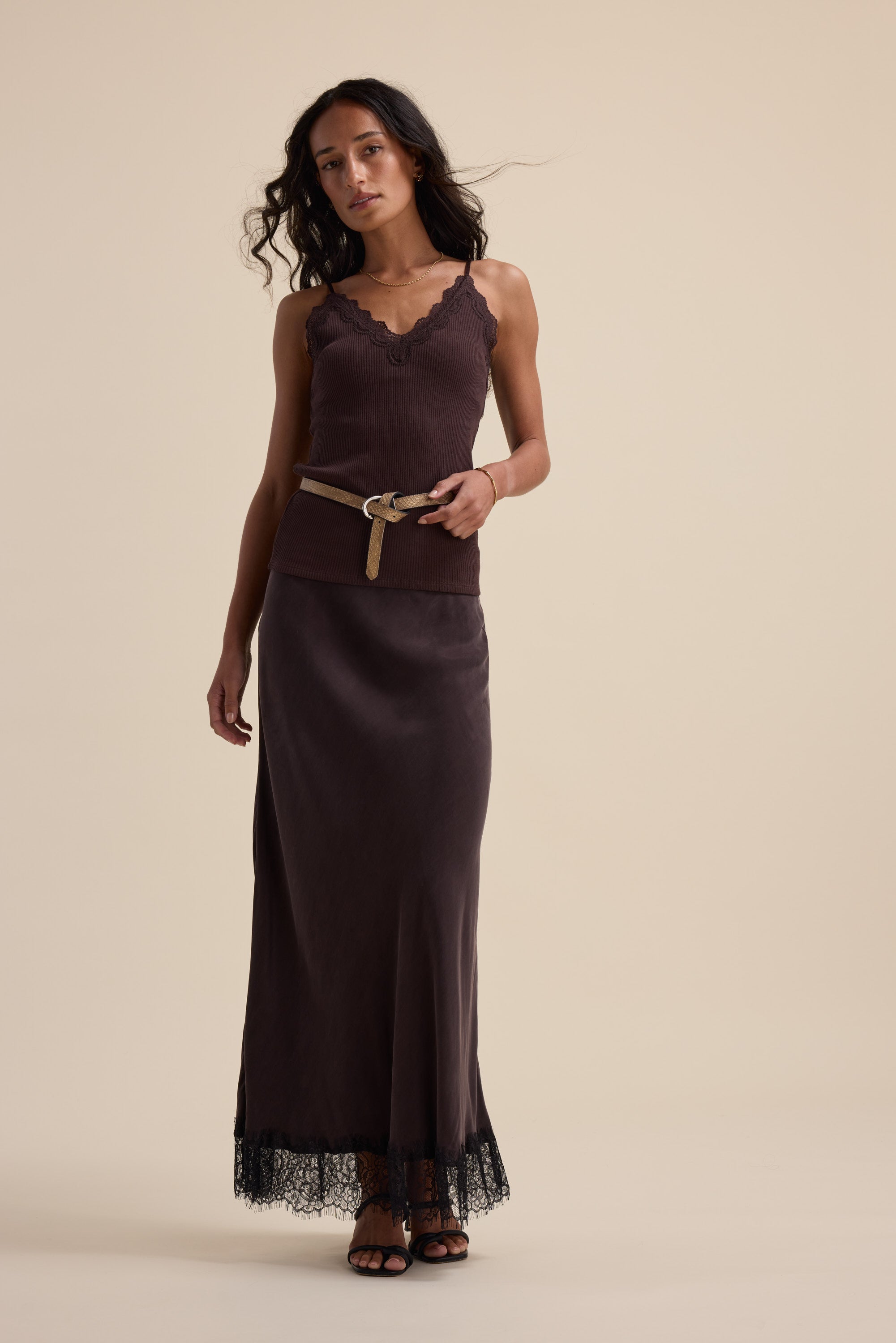 Woman in Max Aubree Lace Trim Tank and long skirt with belt, against beige background.
