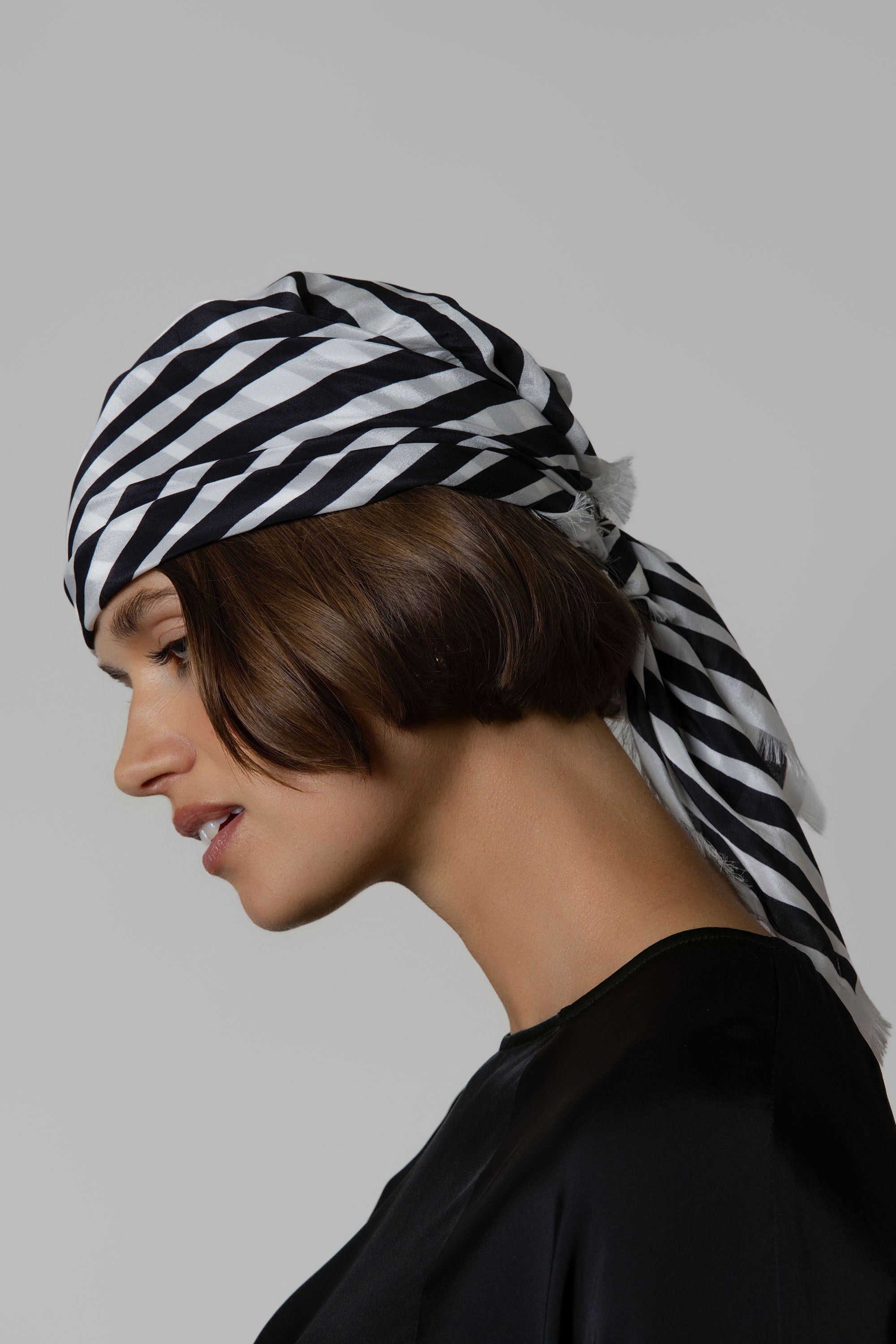 Woman in profile wearing Max's Mable Frayed Edge Silk Scarf and a black top.