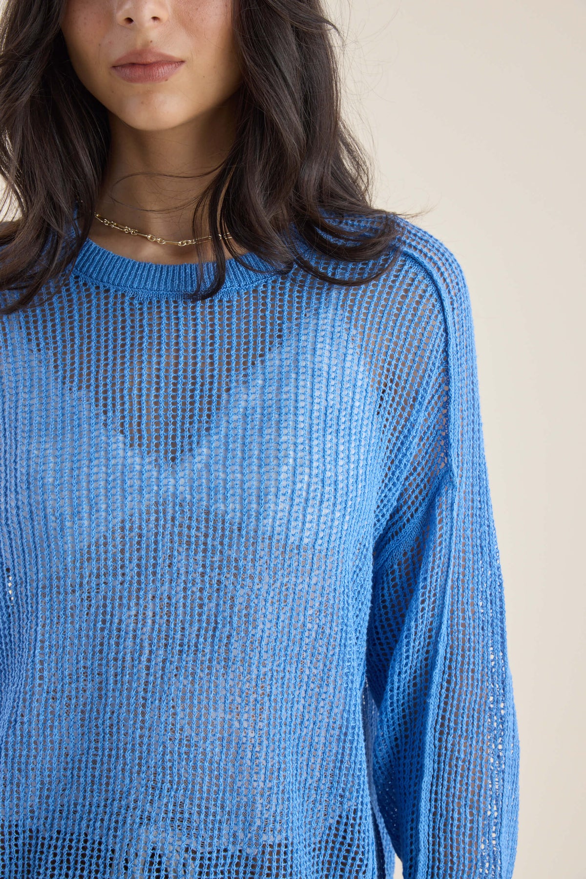 Woman in Elementary Linen Knit Detail Sweater and gold necklace, shown from shoulders up.