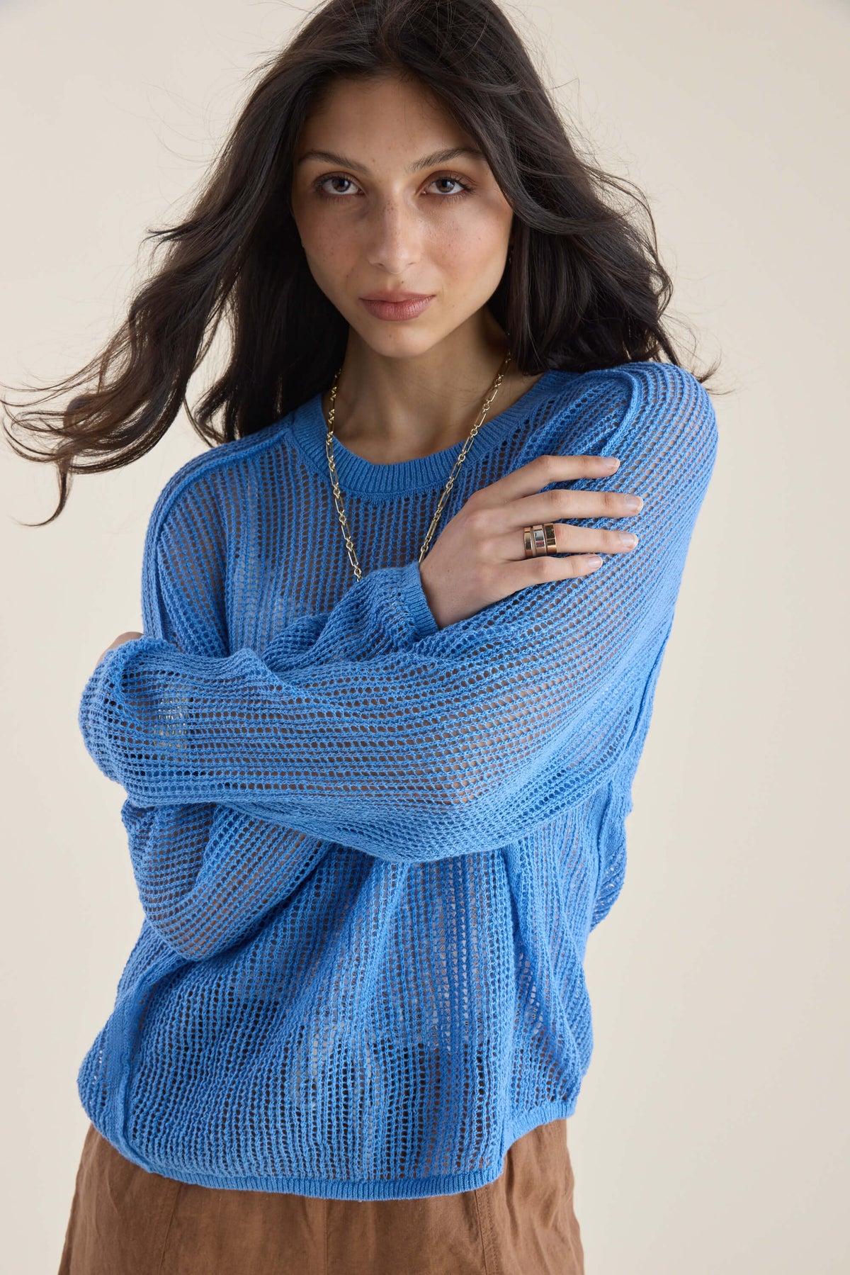 Woman in Elementary Linen Knit Detail Sweater, arms crossed, looking at camera, plain backdrop.